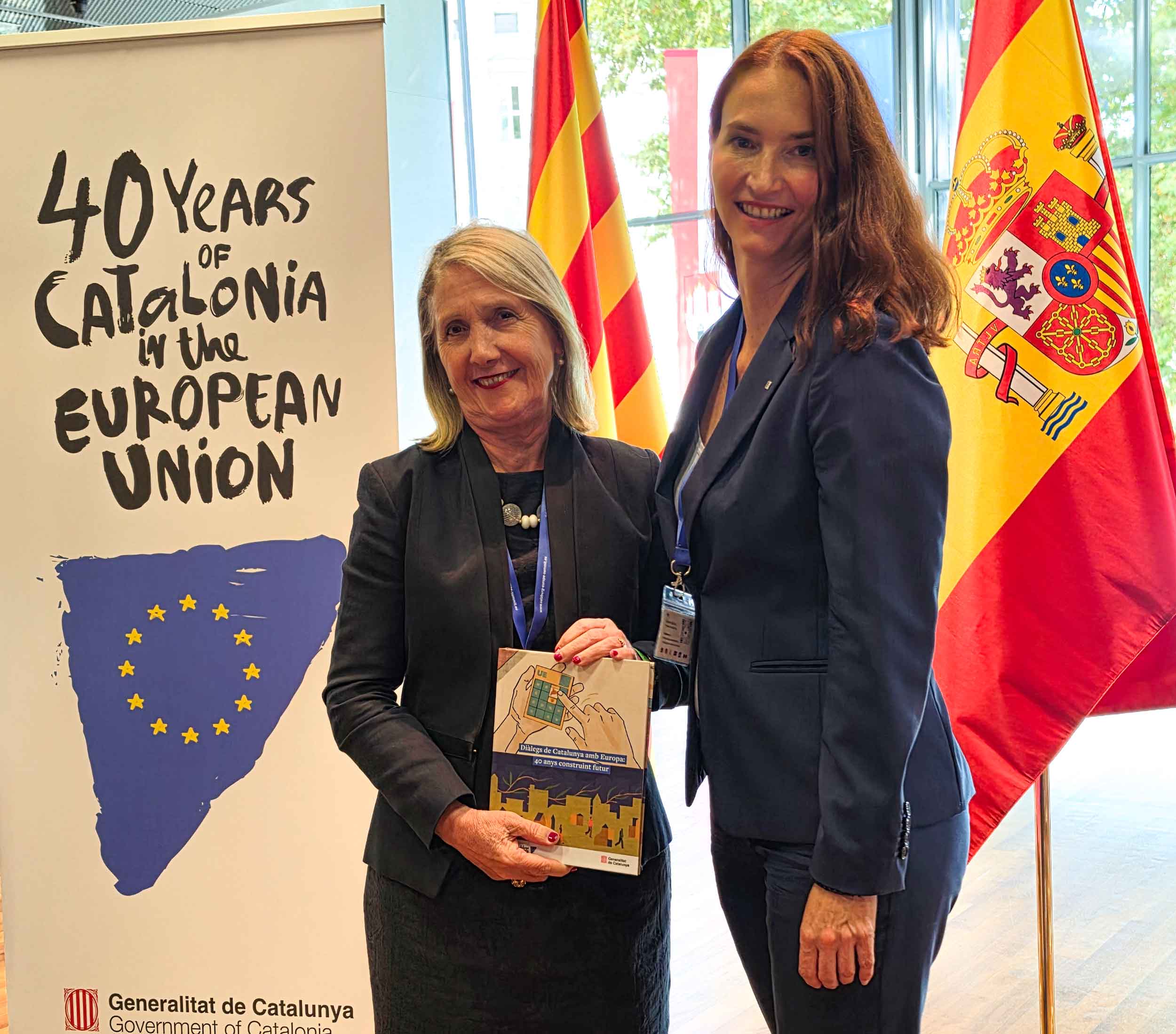 María Mejía, embajadora de España en Austria, junto a Krystyna Schreiber, delegada del Gobierno de Cataluña para Europa Central, con la publicación conmemorativa Diàlegs de Catalunya amb Europa: 40 anys construint futur. Foto: CulturaLatina