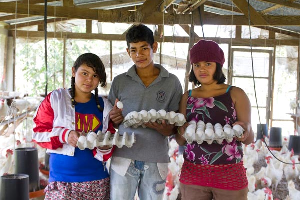 Jóvenes adolescentes aprenden en el gallinero del Centro NPH Honduras.
