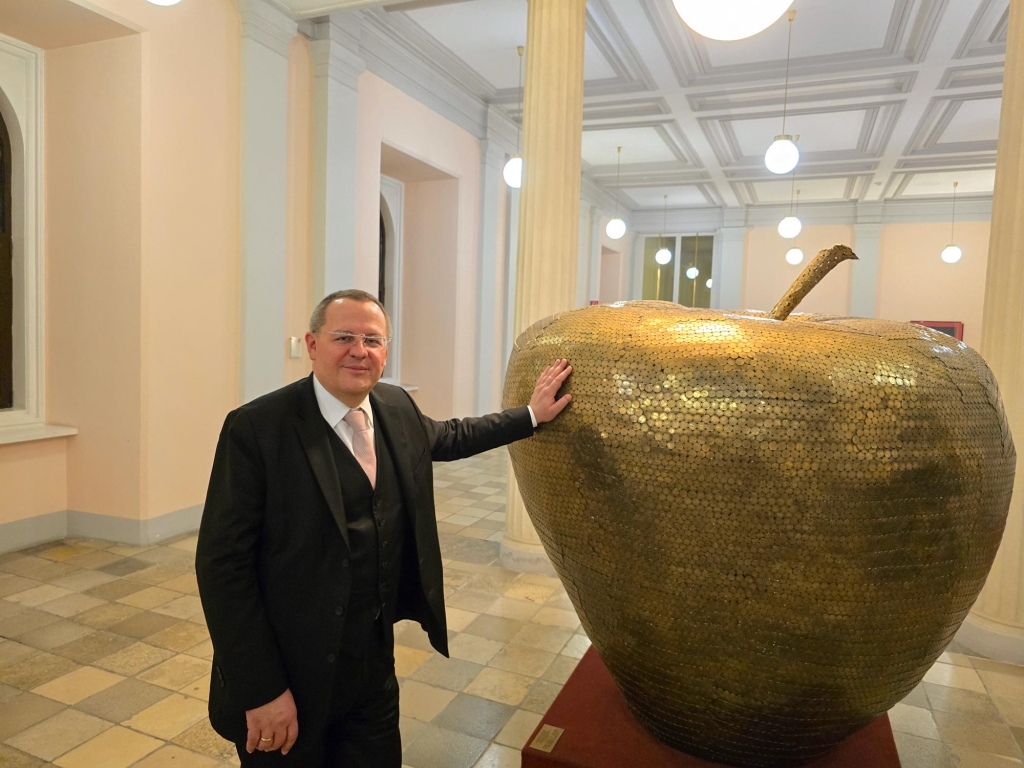 Dr. Manfred Matzinger-Leopold, Vorstandsdirektor der Münze Österreich, neben dem Apfel, ein Werk von Prof. Wu Shaoxiang, das aus 12.000 Stück 1-Schilling-Münzen und 18.000 Stück 50-Groschen-Münzen besteht.